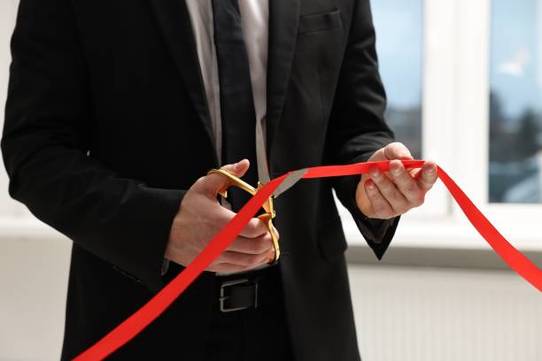 istock Man cutting red ribbon with scissors indoors, closeup 1961176690