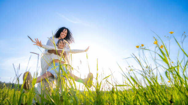 istock Mother spinning daughter in field 1961186224
