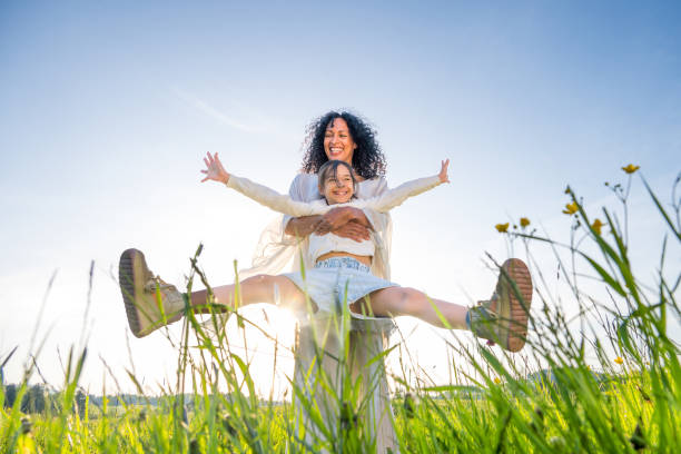 istock Mother spinning daughter in field 1961186751