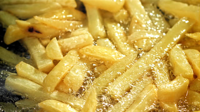 French fries are deep-fried in oil. Filmed on a high-speed camera at 1000 fps.