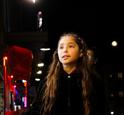 A girl walking in city at night