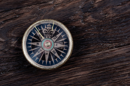 Vintage retro compass on wooden deck background