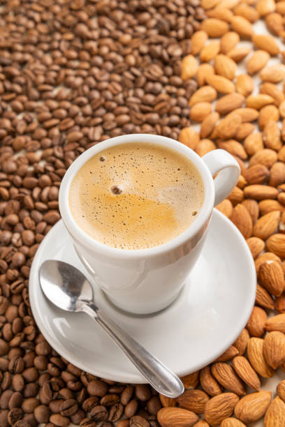 Cup of espresso on coffee beans and almonds