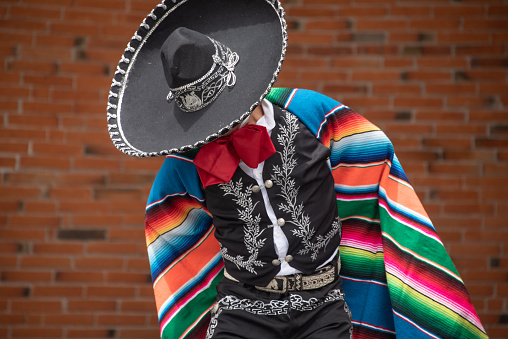 Mexico City, Mexico September /13/2021 Mexican charro dancer from Jalisco Mexico with a multicolored striped serape and large hat with silver decorations in a festival of independence day
