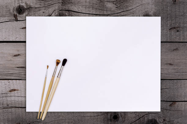 Artist Paint Brush on Blank White Paper. Top View. Drawing Tools in Art Studio.