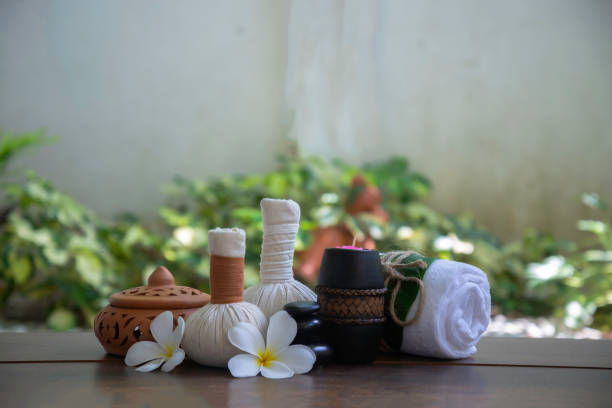 Masseuse carefully placing colorful hibiscus flowers on the surface of water to create a relaxing atmosphere in a Maldives spa