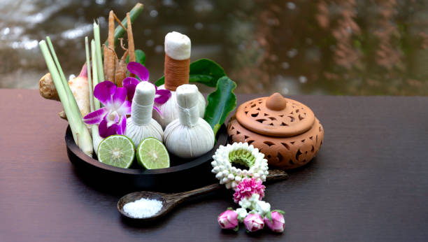 spa massage wellness decorations setting on wood table. thai spa massage traditional compress for hot massage and spa relaxing treatment of office syndrome. massage for health concept. - alternative therapy aromatherapy spa treatment candle photos et images de collection