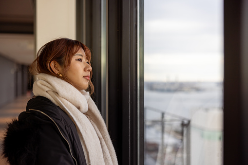 Female tourist looking at view from observatory floor in high raised building