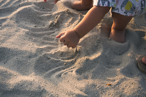 close up of kid hands digging on the beach sand