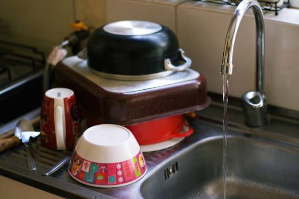 istock dishwasher, sink, running water and washed kitchen utensils 1961641689