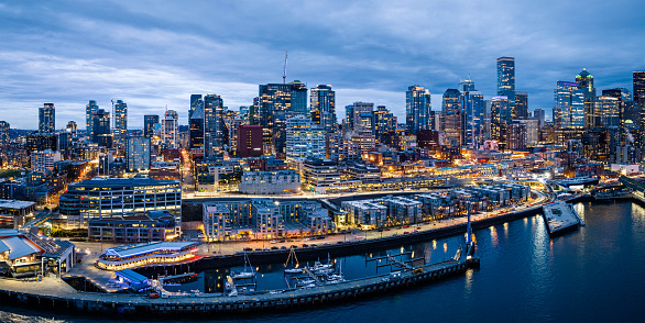 An aerial view of the Seattle Washington waterfront.  A marina and condominiums are visible in the foreground.  In the mid and background are the skyscrapers of the city.