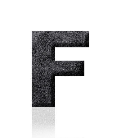 Close-up of three-dimensional black sand alphabet letter F on white background.