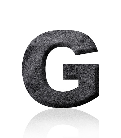 Close-up of three-dimensional black sand alphabet letter G on white background.
