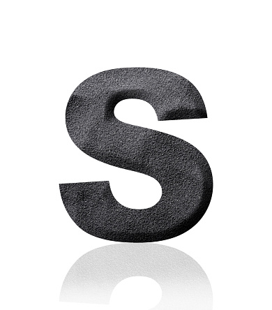 Close-up of three-dimensional black sand alphabet letter S on white background.