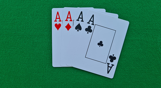Four of kind cards of aces on green felt casino table background. Gambling and casino poker
