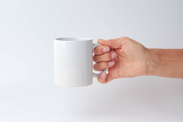 istock Female hand holding coffee mug against white background 1961762039