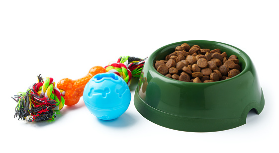 Green plastic bowl with dry pet food isolated on white background