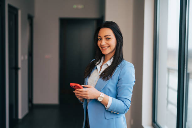 istock Young businesswoman using mobile phone and text messaging 1961778989