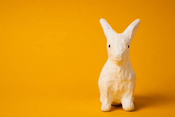 White Easter bunny on a yellow background animal decoration Copy Space. High quality photo