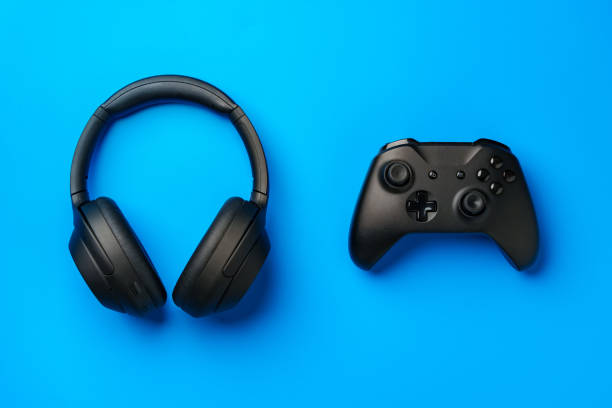 istock Headphones and joystick on blue background top view 1961789626