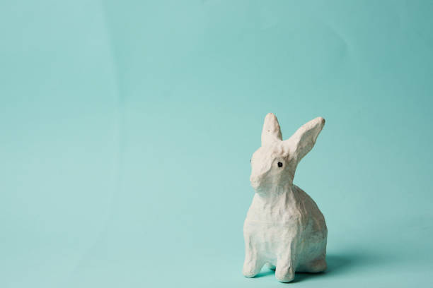 istock Festive white rabbit toy on a blue background with pastel colors Easter 1961794392