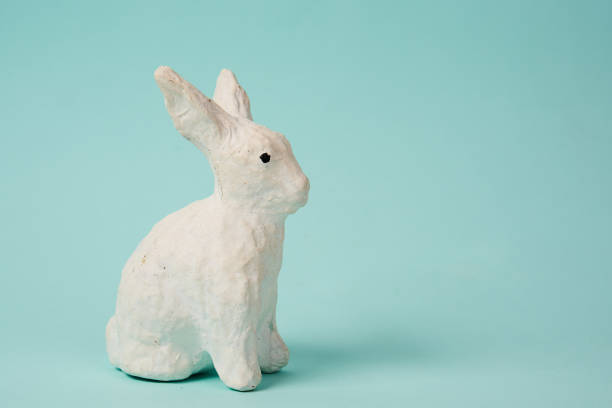 istock Festive white rabbit toy on a blue background with pastel colors Easter 1961794947