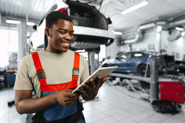 istock Young African auto mechanic using digital tablet in a car service 1961805369