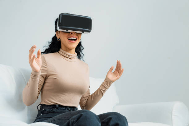 istock Young woman using virtual reality VR goggle at home for crucial experience 1961824210