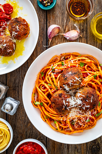 Spaghetti meatballs in tomato sauce on wooden table