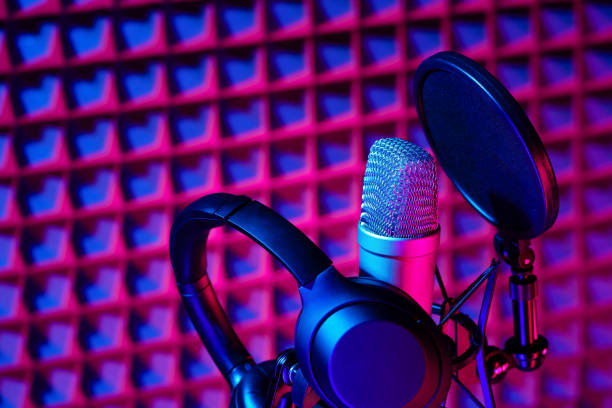 istock Professional studio microphone against acoustic foam panel background in neon light 1961824756