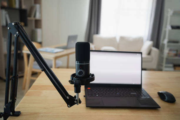 istock Close up view of worktable workplace with laptop and white screen, microphone for streaming or gaming, notebook, and decoration in home office room. Work at home place in the living room concept. 1961853943