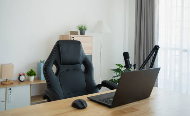 istock Close up view of worktable workplace with laptop and white screen, microphone for streaming or gaming, notebook, and decoration in home office room. Work at home place in the living room concept. 1961854464