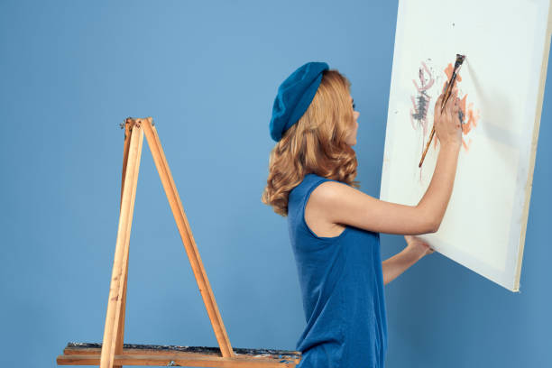 Woman artist easel for drawing art learning blue background blue background. High quality photo