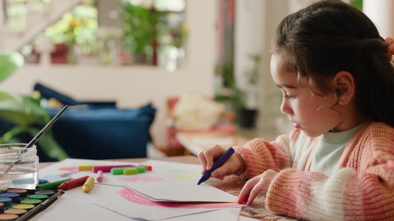 Art, sketch and girl with paper in home with creative learning, drawing and development of education. Child, artist and writing with color pencil on table with inspiration in house for project