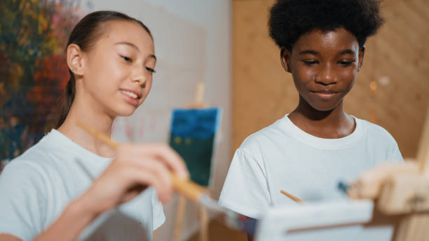 istock Diverse children painting canvas together in creative art lesson. Edification. 1961897212