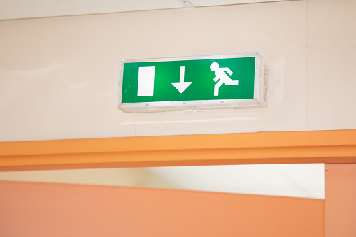 green exit sign with lamps on door Emergency fire  corridor in office building