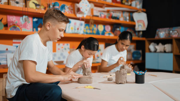 istock Group of happy smart diverse student working with clay at workshop. Edification. 1961935745