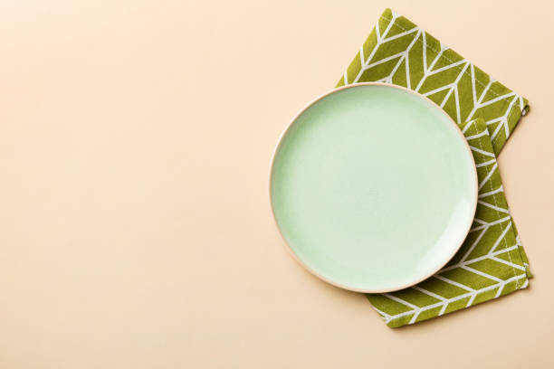 istock Top view on colored background empty round green plate on tablecloth for food. Empty dish on napkin with space for your design 1961939449