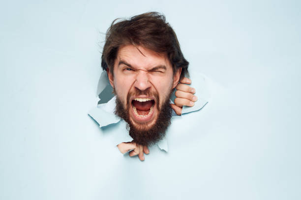 A man under the water of the shower with a serious face, affected. He seeks to disconnect and keep stress and anxiety under control.