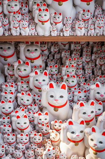 Tokyo, Japan - December 17, 2023: Hundreds of maneki-neko beckoning cat figurines at Gotokuji temple in Tokyo, Japan.