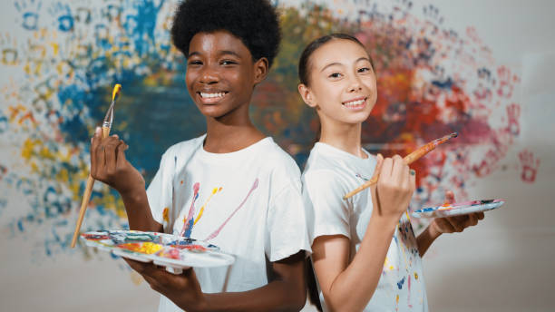 istock Student standing back to back and looking at camera at art lesson. Edification. 1961960762