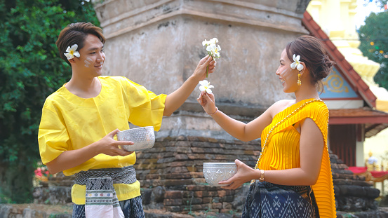 Couple dressed in traditional Thai clothing Playing in the water during Songkran Festival.