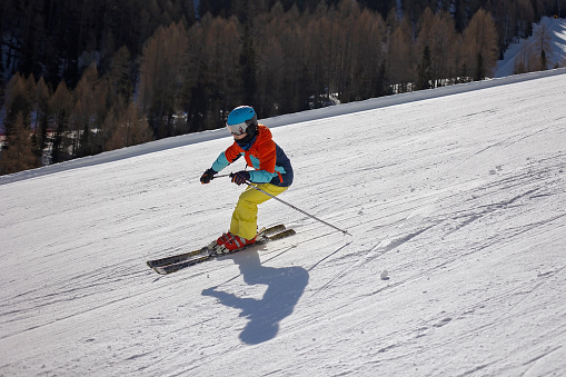 Fast professional skier is riding on ski slope at clear day. Ski resort concept