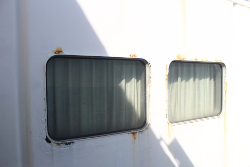 Two curtained windows on the ship