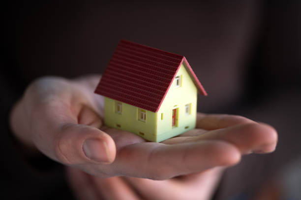 istock Small wooden toy house in hands 1962008686