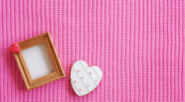 istock Valentine Card Template. Wooden Frame. Space for text. Heart Shape Cookie. Pink knitted background. Wide Horizontal Image 1962019151