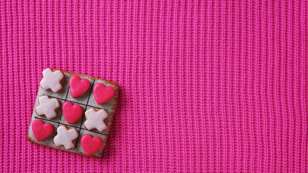 istock A love-themed Tic Tac Toe game set on a pink background, viewed from the top 1962019664
