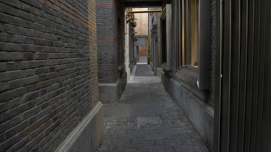 A narrow alley surrounded by grey stone buildings
