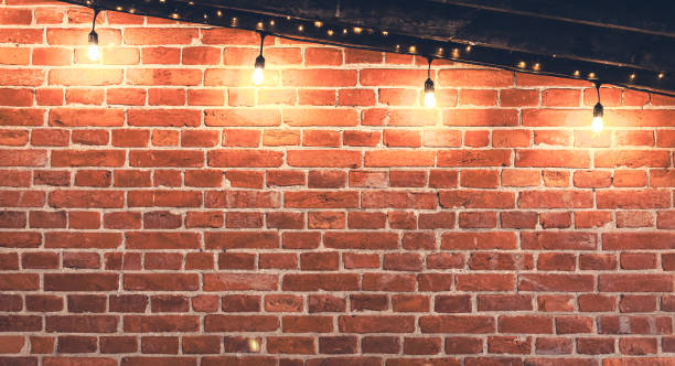 istock Lights garlands hanging from red brick wall at evening. 1962028086