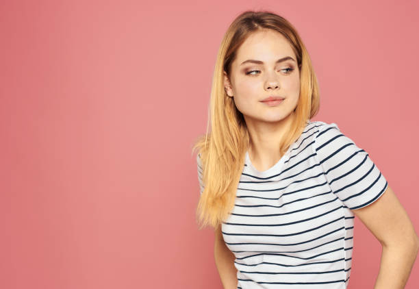 istock Woman model in t-shirt posing on a pink background front view 1962033855